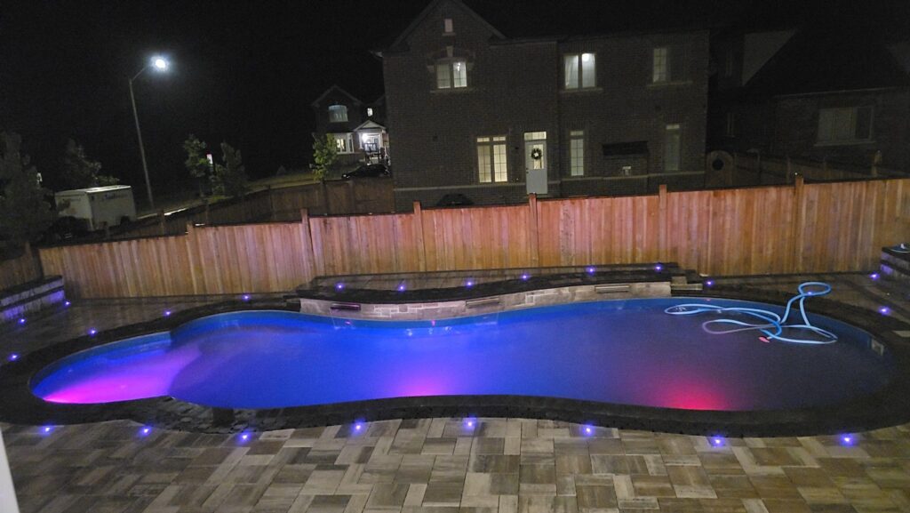 Backyard renovation featuring Onyx bullnose pool coping, Glacier Creek pavers, Parkwall Grey Mix retaining wall by Best Way Stone, and a sheer descent waterfall in Aurora, Stouffville, East Gwillimbury, Nobleton, King City, Richmond Hill, Oakville, North York, Vaughan, Markham, Newmarket, Toronto, Etobicoke, and Mississauga