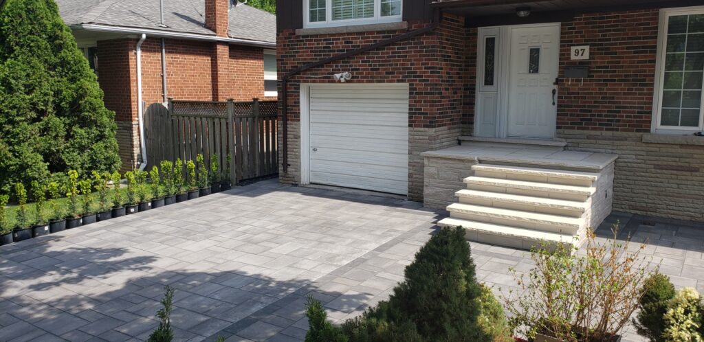 New driveway installed with Tresvista smooth mix in Grey and Adelaide rectangle Ultra Black borders, steps made with Indiana Jurassic coursing and Banas rock-faced Ivory coping around the porch and on the steps