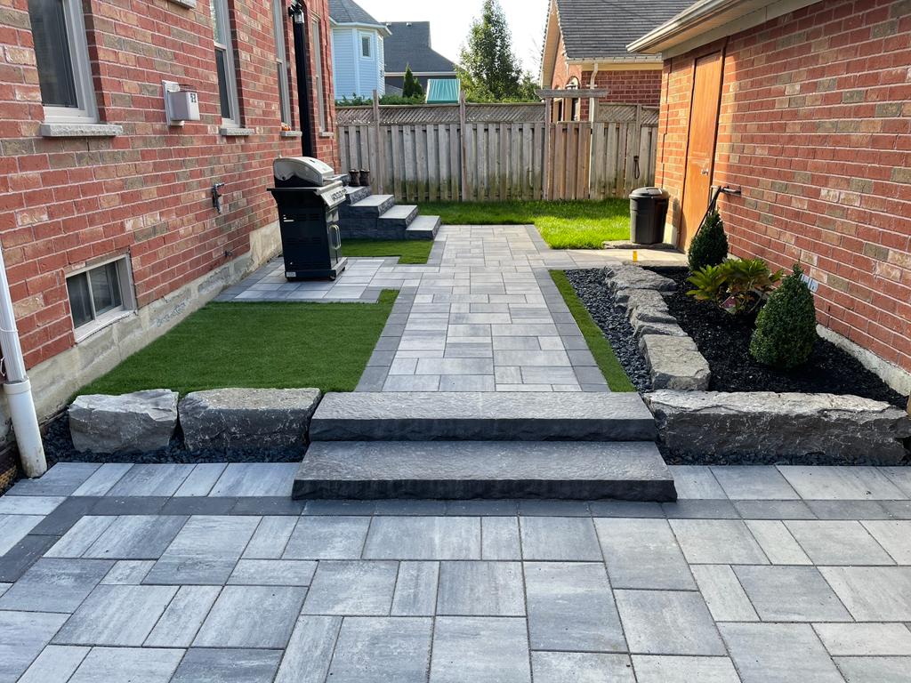 Full backyard landscaping with interlocking patio and natural stone features by Premier Masonry in North York Ontario