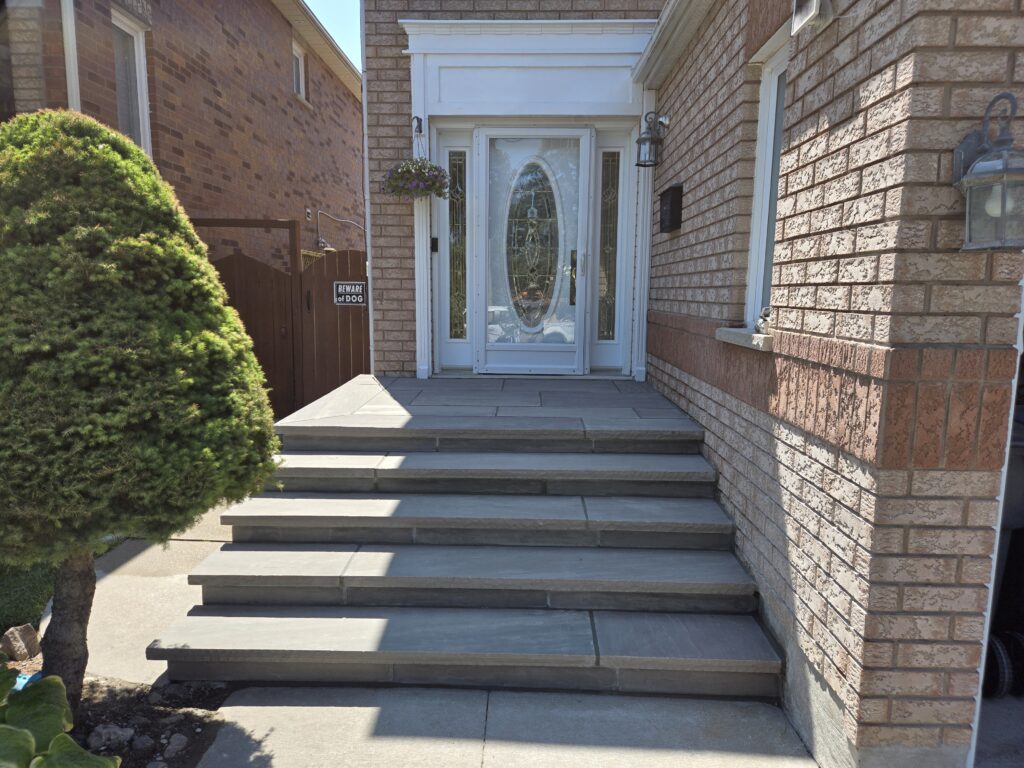 Four custom poured 8 ft steps with 14-inch slate grey rock-faced coping and flagstone porch in Aurora, Newmarket, Stouffville, Richmond Hill, Nobleton, King City, North York, and Oakville
