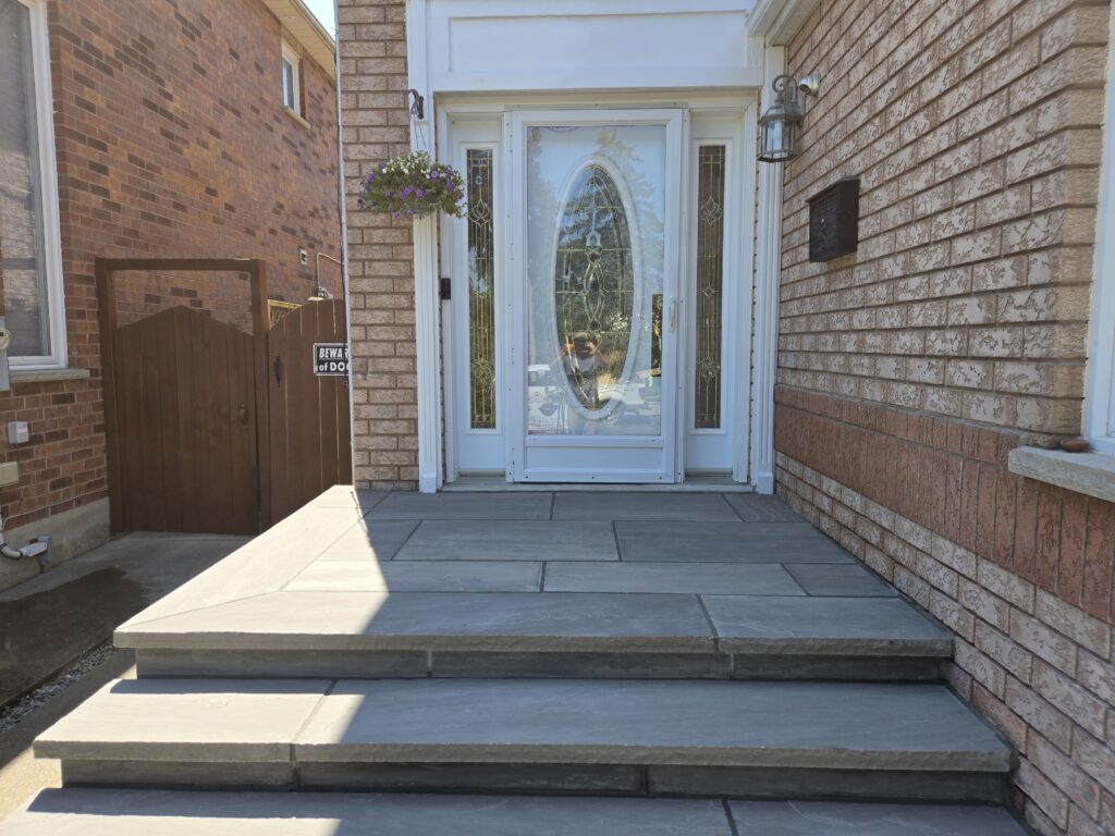 Four custom poured 8 ft steps with 14-inch slate grey rock-faced coping and flagstone porch in Aurora, Newmarket, Stouffville, Richmond Hill, Nobleton, King City, North York, and Oakville