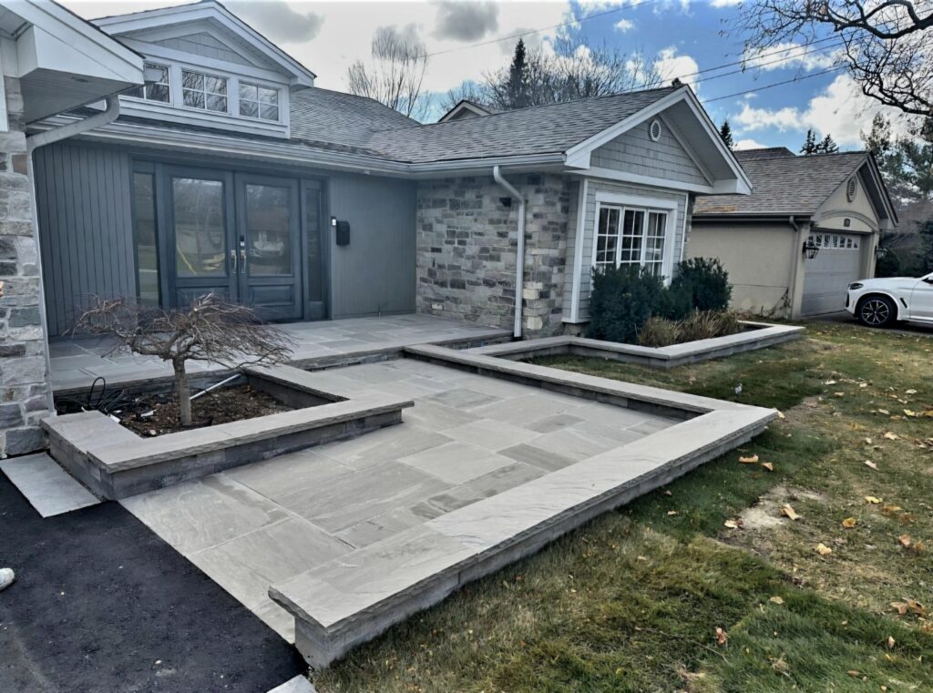 Heated Two-Level Front Landing with Slate Grey Flagstone, Oaks Modan Wall Flower Beds & Slate Grey Rock-Faced Coping | Serving Aurora, Newmarket, Stouffville, Richmond Hill, Nobleton, King City, North York, Vaughan, Etobicoke and Oakville
