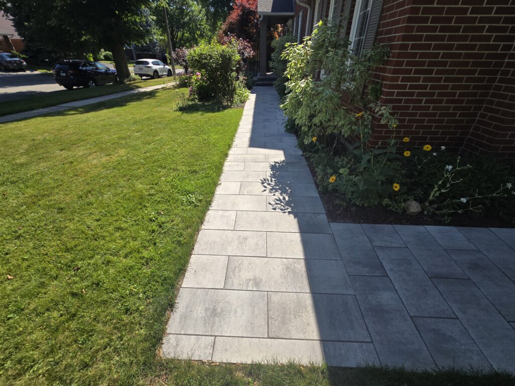Newmarket sidewalk extension featuring Oaks 60mm Marble Grey interlocking pavers connecting the driveway to the side entrance and natural stone front porch.