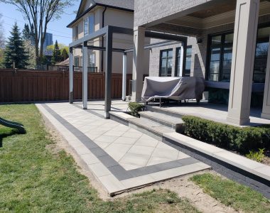 Backyard with Techo-Bloc Para pavers in greyed nickel, onyx borders, diamond pattern, and decorative flower beds