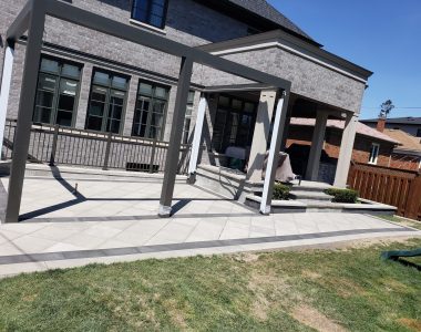 Backyard with Techo-Bloc Para pavers in greyed nickel, onyx borders, diamond pattern, and decorative flower beds