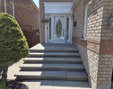 Four custom poured 8 ft steps with 14-inch slate grey rock-faced coping and flagstone porch